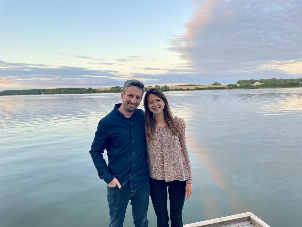 Two group members stand in front of a scenic waterway in Aarhus for the Mnemonics 2021 Conference “Memory and Migration.” 