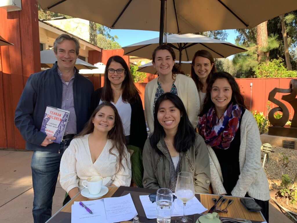 Members of the Working Group in Memory Studies pose with  Mikhal Dekel at an outdoor patio. 